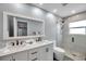 Modern bathroom featuring double sink vanity with sleek fixtures and a glass-enclosed shower with gray tiling at 9394 117Th Ave, Largo, FL 33773