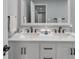 Bathroom vanity featuring double sinks, modern fixtures, white cabinets, and a large mirror at 9394 117Th Ave, Largo, FL 33773