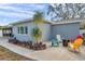 Charming home exterior featuring a cozy patio with colorful chairs and a well-manicured garden at 9394 117Th Ave, Largo, FL 33773