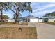 Traditional home with a green lawn, mature trees, and a mailbox at 9394 117Th Ave, Largo, FL 33773