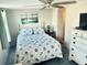 Cozy bedroom with a nautical themed quilt, light walls and a ceiling fan at 9790 66Th N St # 235, Pinellas Park, FL 33782