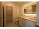 Bathroom featuring double sink vanity with a large, lighted mirror, and a walk-in closet at 1018 Blakley St, Punta Gorda, FL 33980