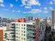 Elevated view of a modern condo building with balconies and cityscape backdrop under a blue sky at 1208 E Kennedy Blvd # 1115, Tampa, FL 33602