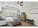 Main bedroom features a ceiling fan, wood floor and a lot of natural light from the large window at 12326 Terracina Chase Ct, Tampa, FL 33625