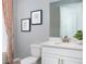 Bathroom with a toilet, bathtub, shower curtain, sink, and decorative artwork at 12419 Hearts Ease St, Venice, FL 34293