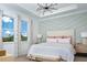 Bright main bedroom with chevron accent wall, tray ceiling, modern light fixture and large windows at 12419 Hearts Ease St, Venice, FL 34293