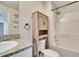 Bathroom featuring granite countertops, rustic wood cabinet over the toilet, and a shower/tub combo at 12818 Crested Iris Way, Riverview, FL 33579