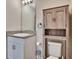 Well-lit bathroom featuring granite countertops and rustic wood cabinet over the toilet at 12818 Crested Iris Way, Riverview, FL 33579