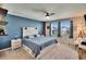 Beautiful bedroom featuring a ceiling fan, a large bed with gray bedding, and lots of natural light from the two windows at 12818 Crested Iris Way, Riverview, FL 33579