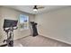 Exercise room featuring a treadmill, stationary bike, ceiling fan, and a window for natural light at 12818 Crested Iris Way, Riverview, FL 33579