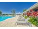 Lounge chairs beside community pool with view of clubhouse and lush landscaping at 12818 Crested Iris Way, Riverview, FL 33579