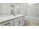 Stylish bathroom featuring a large mirror, white vanity, and a shower-tub combo at 13729 Evergreen Valley Dr, Riverview, FL 33578