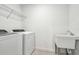 Laundry room featuring appliances, sink, and metal storage shelf at 13729 Evergreen Valley Dr, Riverview, FL 33578