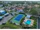 Aerial shot featuring a tennis court, community pool, and parking area at 14505 Catalina Cir, Seminole, FL 33776