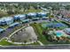 Aerial view of townhomes featuring pond with fountain, tennis court, and community pool at 14505 Catalina Cir, Seminole, FL 33776