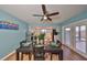 Bright dining area with a ceiling fan, stylish table setting, and access to an outdoor patio at 14505 Catalina Cir, Seminole, FL 33776