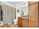 Well-lit bathroom featuring vanity, cabinets, toilet, shower and patterned curtain at 1545 Emerald Dunes Dr, Sun City Center, FL 33573