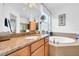 Bathroom with double sink and granite countertops, as well as a soaking tub at 1545 Emerald Dunes Dr, Sun City Center, FL 33573