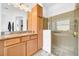 Bathroom featuring granite counters, wooden cabinets, and walk-in shower at 1545 Emerald Dunes Dr, Sun City Center, FL 33573