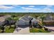 Aerial view of a well-maintained property with lush landscaping, a three-car garage, and a spacious layout at 1545 Emerald Dunes Dr, Sun City Center, FL 33573