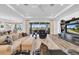 Bright living room featuring wood floors, tray ceiling, comfortable seating, and sliding doors to the lanai at 1545 Emerald Dunes Dr, Sun City Center, FL 33573