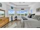 Bright main bedroom features plenty of natural light, wooden floors, and dresser with wall mirror at 1545 Emerald Dunes Dr, Sun City Center, FL 33573