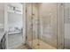 Modern bathroom features a glass shower with beige tile and a glimpse of a vanity and couch through the doorway at 18 Franklin S Ct # D, St Petersburg, FL 33711