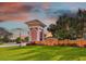 Community entrance featuring lush landscaping, and a welcoming sign, set against a colorful sky at 18 Franklin S Ct # D, St Petersburg, FL 33711