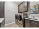 Efficient laundry room with modern, front-load washer and dryer and dark cabinets with light countertops at 18 Franklin S Ct # D, St Petersburg, FL 33711