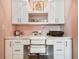 Detailed view of a charming, pink office nook featuring custom cabinets, shelving, and a white modern desk at 18 Franklin S Ct # D, St Petersburg, FL 33711