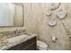 Chic powder room featuring leaf-patterned wallpaper, a dark vanity with granite top, and unique wall decor at 18 Franklin S Ct # D, St Petersburg, FL 33711