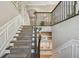 Beautiful staircase with carpeted steps, a dark wood banister, and decorative wainscoting at 18 Franklin S Ct # D, St Petersburg, FL 33711