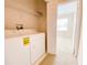 Practical laundry room with washer, dryer, and shelving for storage at 18001 Richmond Place Dr # 222, Tampa, FL 33647