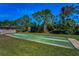 Outdoor bocce ball court next to a community building surrounded by green grass and trees at 2492 Laurelwood Dr # E, Clearwater, FL 33763