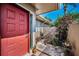 Charming covered entrance featuring a red door and manicured plants at 2492 Laurelwood Dr # E, Clearwater, FL 33763