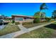 Charming one-story home with lush landscaping, sidewalk, and bright blue sky at 2492 Laurelwood Dr # E, Clearwater, FL 33763