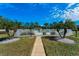 Entrance to pool area through a walkway lined with rocks, tropical plants, and a white metal fence at 2492 Laurelwood Dr # E, Clearwater, FL 33763