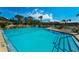 Large community pool on a sunny day with lounge chairs and tables available for relaxation at 2492 Laurelwood Dr # E, Clearwater, FL 33763