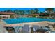 Community pool with lounge chairs near the pool deck with a clear blue sky above the landscape at 2492 Laurelwood Dr # E, Clearwater, FL 33763