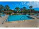 Inviting community pool with sparkling blue water surrounded by lush greenery and comfortable lounge chairs at 2492 Laurelwood Dr # E, Clearwater, FL 33763