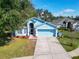 Two-story home in light blue features a two-car garage, an open lawn, and beautiful landscaping at 3902 Ixora Ct, Riverview, FL 33578