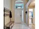 Welcoming foyer with a bench, coat rack, and bright natural light from the transom window at 3902 Ixora Ct, Riverview, FL 33578