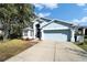 Charming light blue home with a two car garage, landscaped front yard and a concrete driveway at 3902 Ixora Ct, Riverview, FL 33578