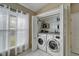 Convenient laundry closet featuring a washer and dryer, shelving, and window at 3902 Ixora Ct, Riverview, FL 33578