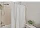 Updated bathroom features a tile surround shower-tub combo and linen curtain at 4303 Ortona Ln, Wesley Chapel, FL 33543