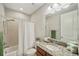 Bright bathroom features granite vanity top and shower-tub combo with white shower curtain at 4303 Ortona Ln, Wesley Chapel, FL 33543