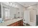 Well-lit bathroom features a granite countertop, ample cabinet space, and a shower-tub combination at 4303 Ortona Ln, Wesley Chapel, FL 33543