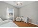 Bright bedroom featuring hardwood floors, a cozy armchair, and large window with natural light at 4303 Ortona Ln, Wesley Chapel, FL 33543