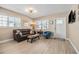 Comfortable living room featuring tile flooring, a leather sofa, and bright natural light from two windows at 4310 W San Luis St, Tampa, FL 33629