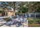 Backyard with a stone fire pit, seating area, storage shed and mature trees at 4807 Wynwood Dr, Tampa, FL 33615